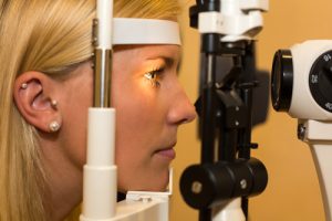 Patient or customer at slit lamp at optometrist or optician